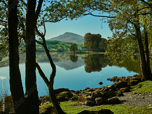Bala Lake or Llyn Tegid, Bala, Snowdonia. A view of Bala lake with clear blue sky and mountains reflected on the water. In the distance is Aran Benllyn with the peak of Aran Fawddwy on the skyline. photo