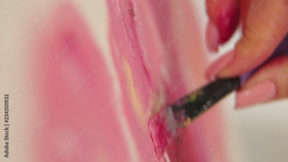Close-up of the girl artist draws pink flowers on a white canvas. Art. Close-up of the girl artist draws pink flowers on a white canvas. Art.