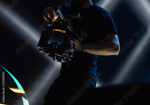 Professional videographer holding camera on 3-axis gimbal. Videographer using steadicam. Pro equipment helps to make high quality video without shaking