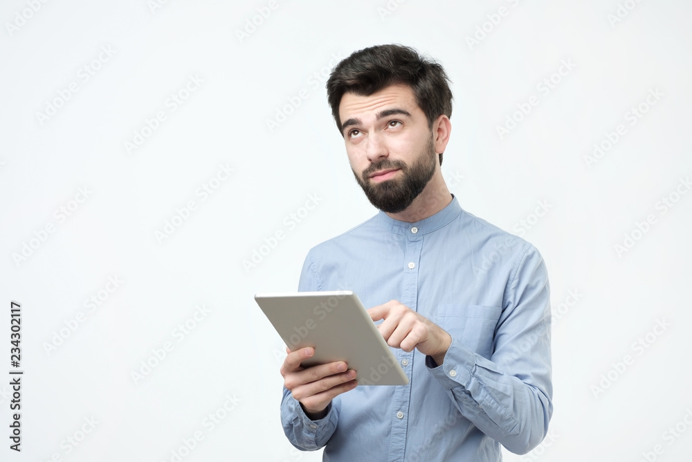 Handsome man using tablet on white background. Studio shoot Handsome man using tablet on white background. Studio shoot