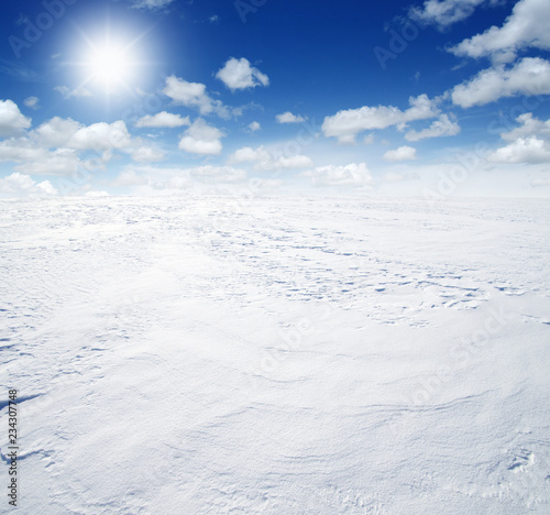 Snowcovered fields on sky and sun.