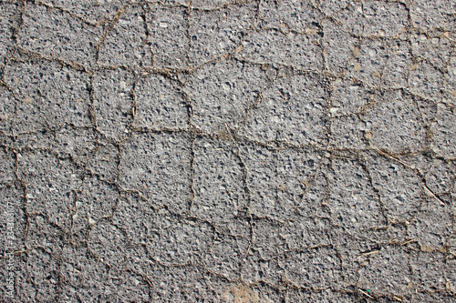 Old asphalt surface texture detail with cracks fractures lines close up
