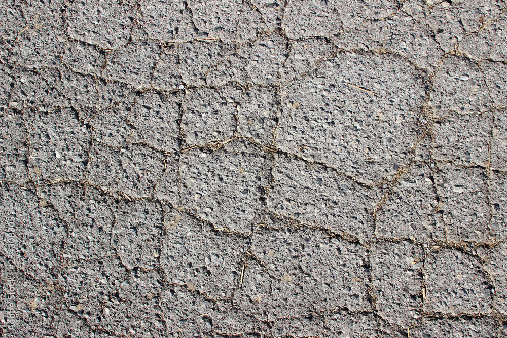 Old asphalt surface texture detail with cracks fractures lines close up