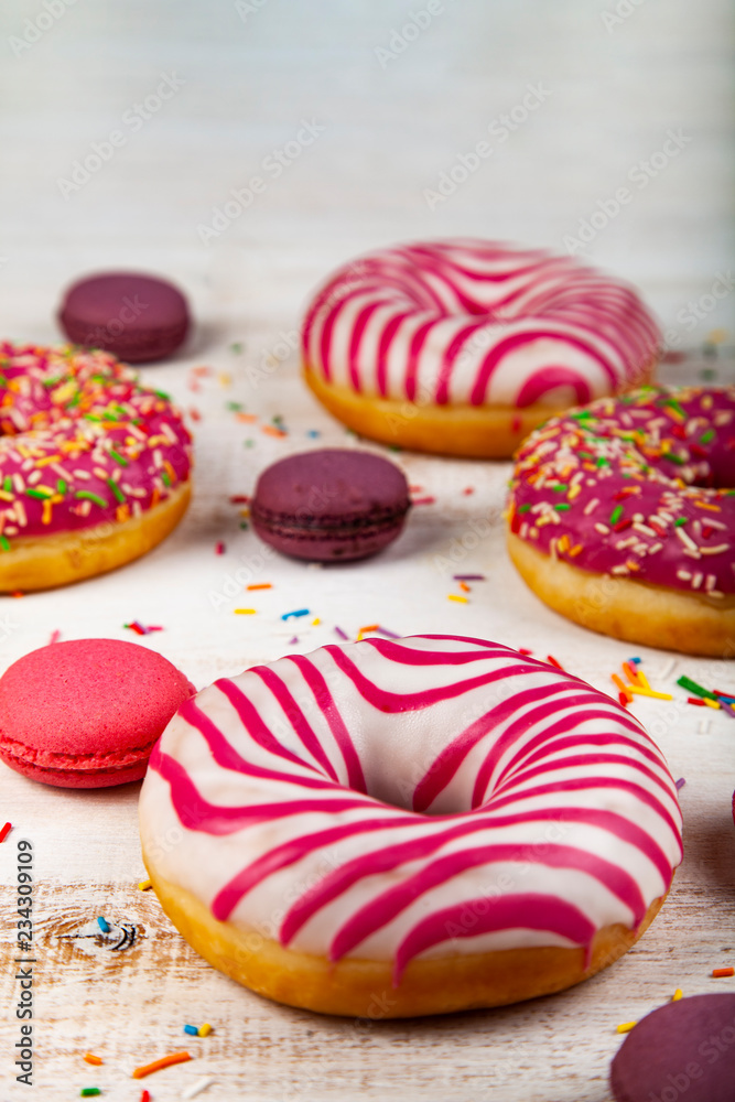 Donuts and macaroons on a wooden background. Donuts and macaroons on a wooden background.
