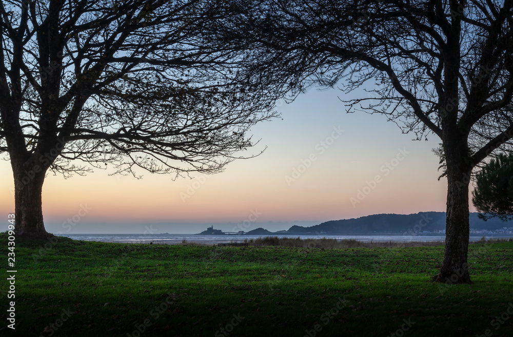 Dawn at Mumbles headland The iconic Mumbles headland taken from Blackpill promenade, Swansea, UK Dawn at Mumbles headland The iconic Mumbles headland taken from Blackpill promenade, Swansea, UK