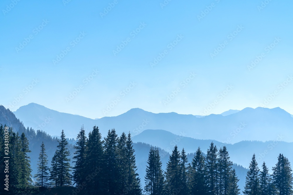 Scenic Panorama picture or postcard view of layer mountain,Forest wood and blue sky background with mountain Alps, Beautiful outdoor scene landscape.Vacation Holiday. 