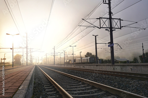 Railway station in the morning on sunrise. Industrial landscape with railroad,Beautiful sky with mist, sunlight, trains in background. Railway junction. Heavy industry.Scenery in autumn winter.