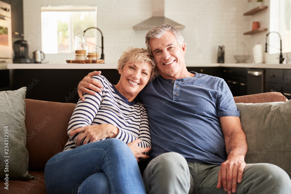 Senior white couple relaxing at home smiling to camera Senior white couple relaxing at home smiling to camera