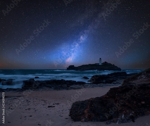 Vibrant Milky Way composite image over landscape of Godrevy lighthouse on Cornwall coastline in England © veneratio