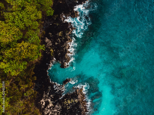 Blue ocean in tropics with rocky coast. Aerial view. © artifirsov