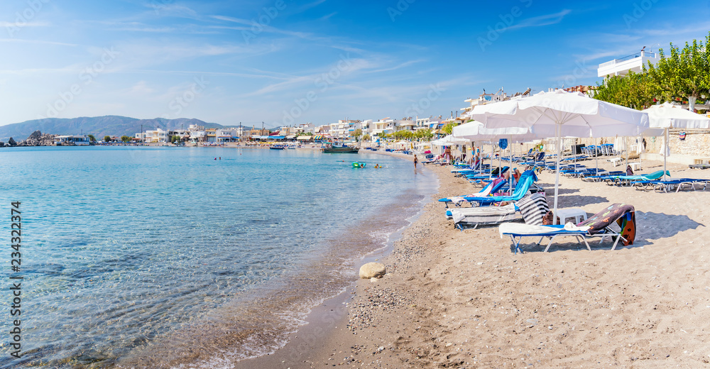 Sun beds and sun shades in Haraki beach – (Rhodes, Greece)