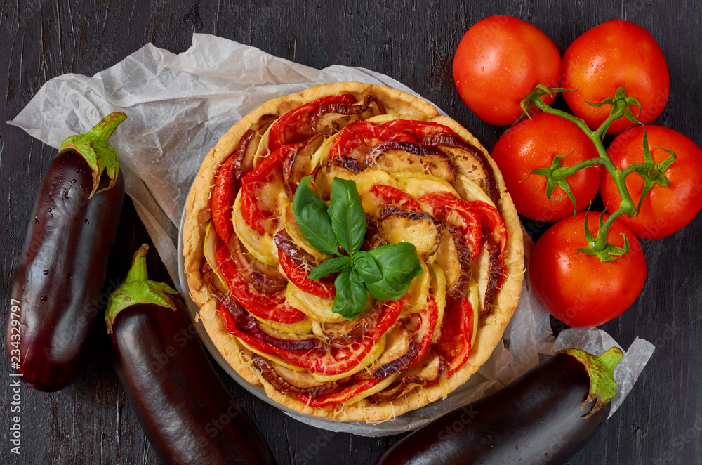 Traditional French quiche with vegetables and cheese on the black wooden  background. Vegetarian tart decorated with fresh eggplants, tomatoes and  basil leaves. Top view Stock Photo | Adobe Stock
