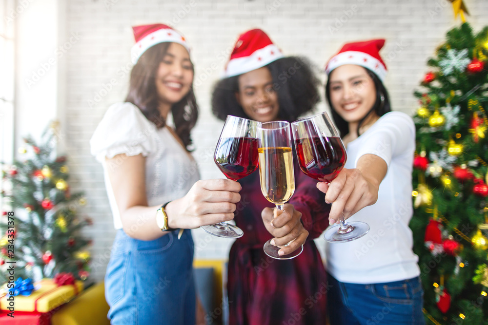 Obraz premium Happy girl friends having new year party toasting with red wine and champagne