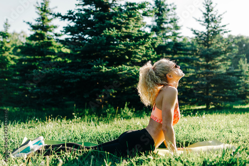 Photo of young curly-haired sports woman practicing yoga on rug  photo