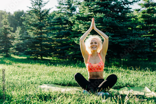 Photo of young curly-haired sports woman practicing yoga on rug  photo