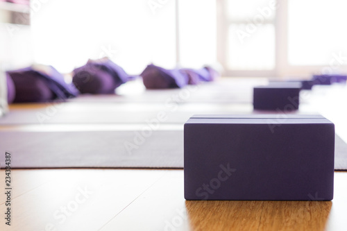 Empty, bright Yoga studio with mats and foam blocks. Wooden floor. Horizontal.