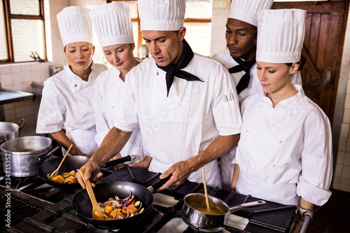 Head chef teaching his team to prepare a food
