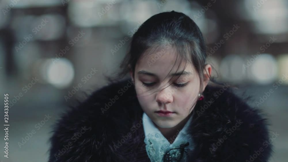 Sad cute little girl with dark hair looking down. Portrait upset of Caucasian girl. Sad cute little girl with dark hair looking down. Portrait upset of Caucasian girl.