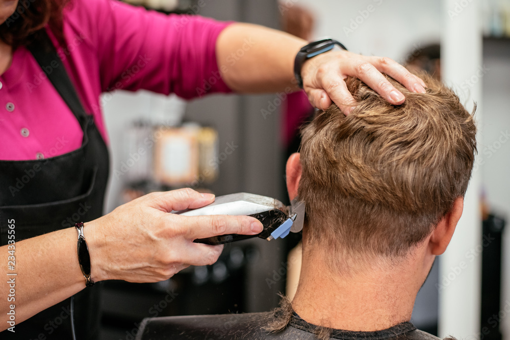 Man having his hair cut in a barbershop Man having his hair cut in a barbershop