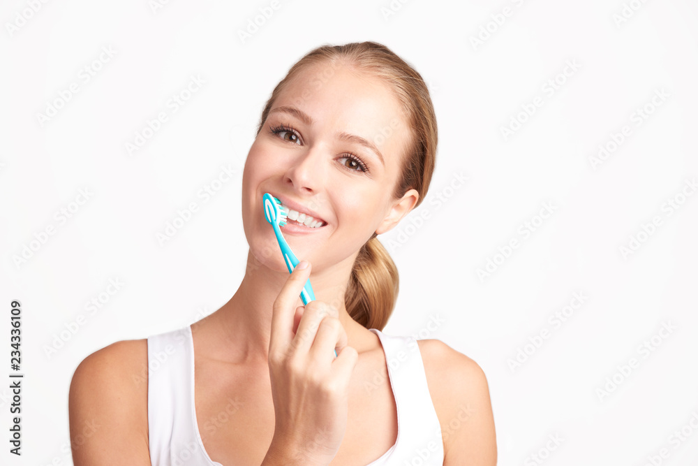 Beautiful young woman brushing her teeth against white background Beautiful young woman brushing her teeth against white background
