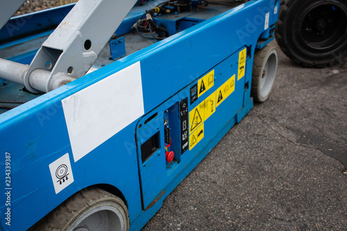Lower part of bluenscissor lift. Various buttons for operating machine.