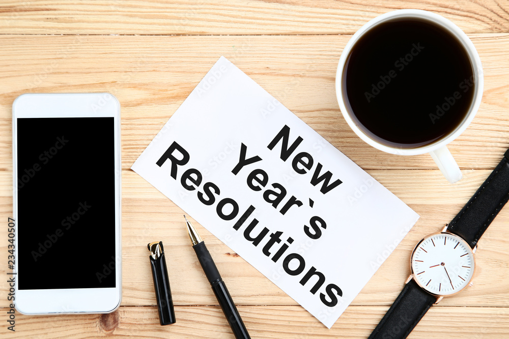 New year resolutions on sheet of paper with smartphone, wrist watch and cup of coffee New year resolutions on sheet of paper with smartphone, wrist watch and cup of coffee