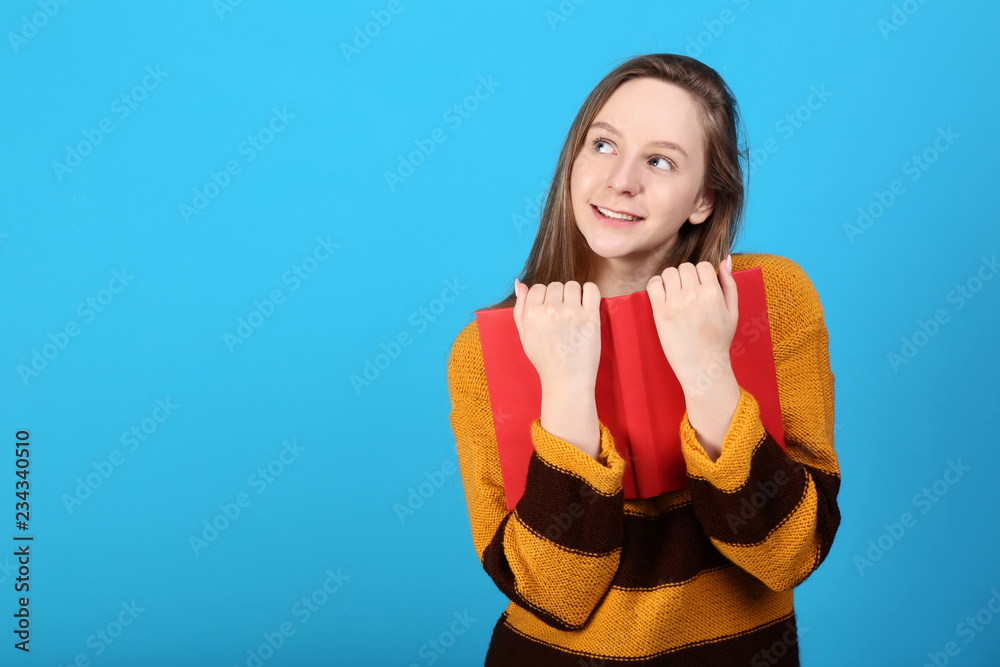 Young girl with red book on blue background Young girl with red book on blue background