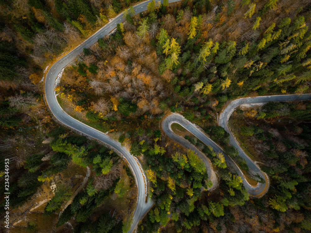 Winding road in mountains, fall woodlands, drone view from above Winding road in mountains, fall woodlands, drone view from above