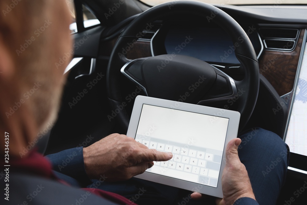 Businessman using digital tablet in a car Businessman using digital tablet in a car