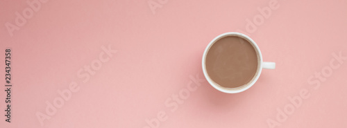 Cup of coffee with milk on pink background