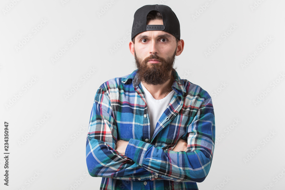 Beauty, fashion and people concept - Portrait of a young bearded hipster stylish guy over white background. Beauty, fashion and people concept - Portrait of a young bearded hipster stylish guy over white background.