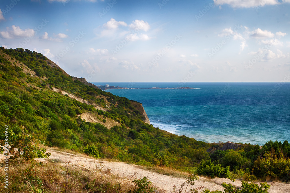 Seascape, clear sky. Summer panorama, green vegetation. Calm sea. Seascape, clear sky. Summer panorama, green vegetation. Calm sea.