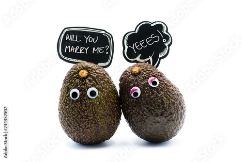 Romantic avocados couple with googly eyes and speech bubbles with text Will You Marry Me, funny food and love concept for creative projects