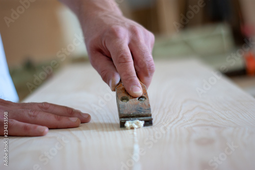 carpenter cleans glue residue from wooden parts