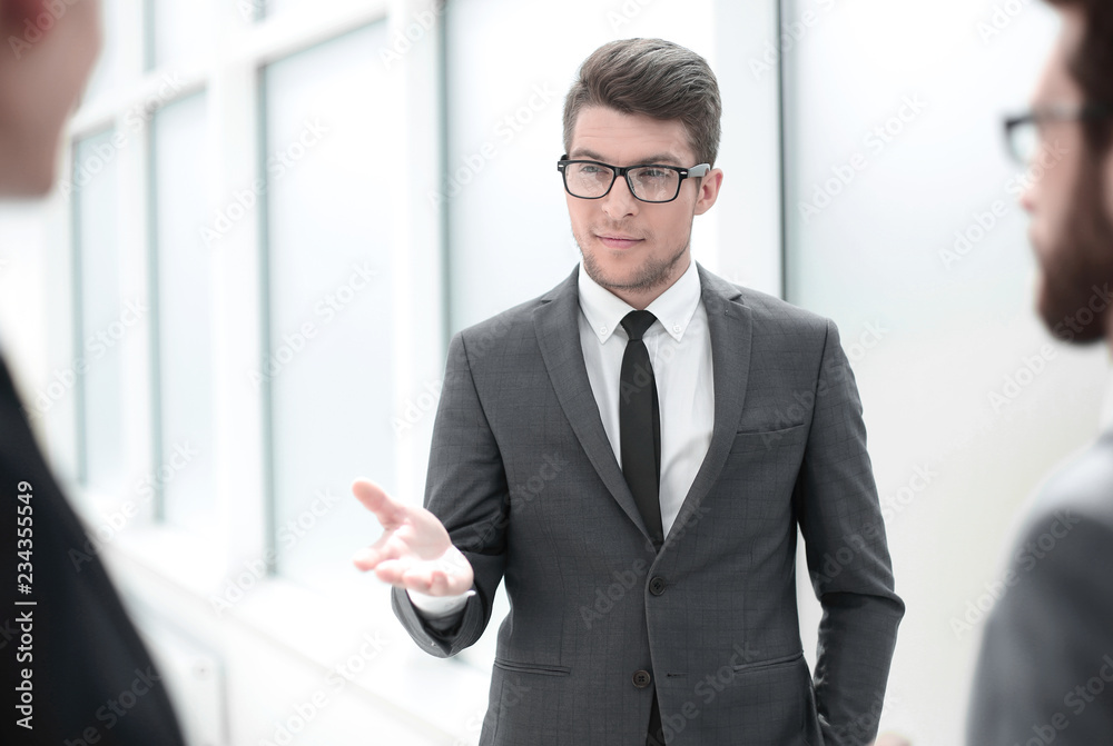 boss talking to employees standing in the office boss talking to employees standing in the office