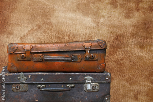 Old vintage travel suitcases over brown leather