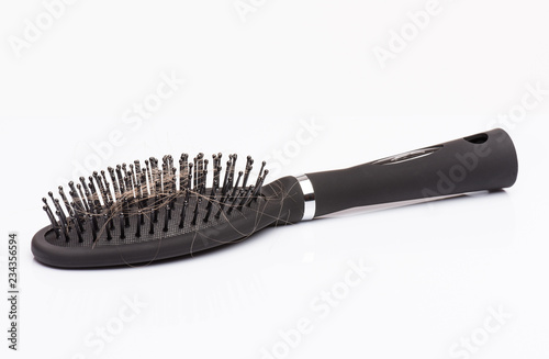 Hair loss problem - black hair comb brush with lost hair on it  isolated white background. Full depth of field with clipping path.