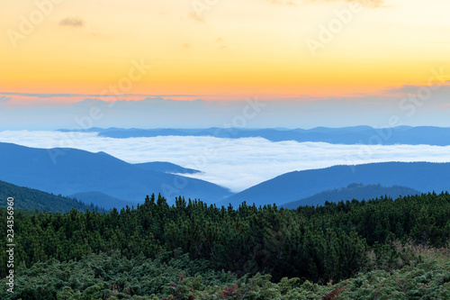 Sunrise on the top of Carpathian mountains over the clouds, awesome nature landscape in early morning