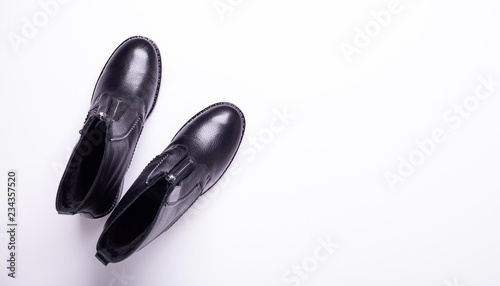 Woman accessory. Black stylish boots on white background. Top view background. Flat lay. Copy space.