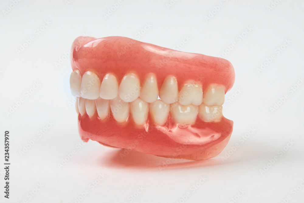 Obraz premium Artificial teeth on a white background with copy space.