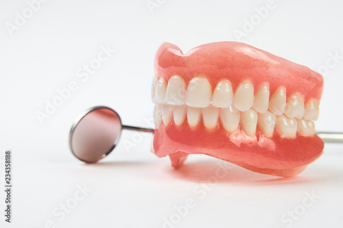 Artificial teeth on a white background with copy space.