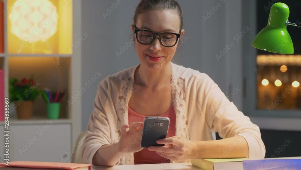 Woman in glasses sitting at desk in the evening