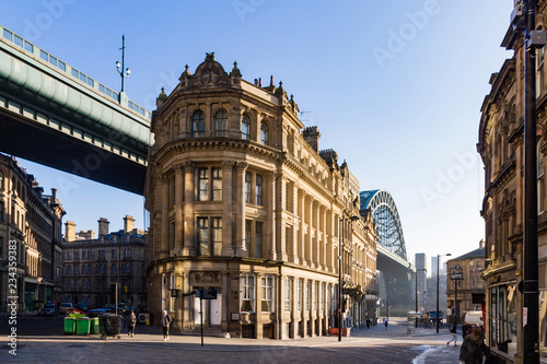 Golden light shining on the Tyne Bridge and Georgian buildings on Queen's street in Newcastle Upon Tyne photo