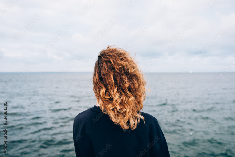 Fototapeta premium Female with red curly hair outdoors standing