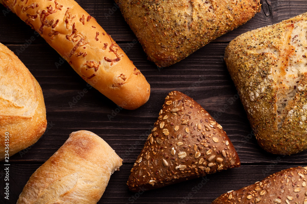 Foto de Breads of different types and shapes are spread out on a black