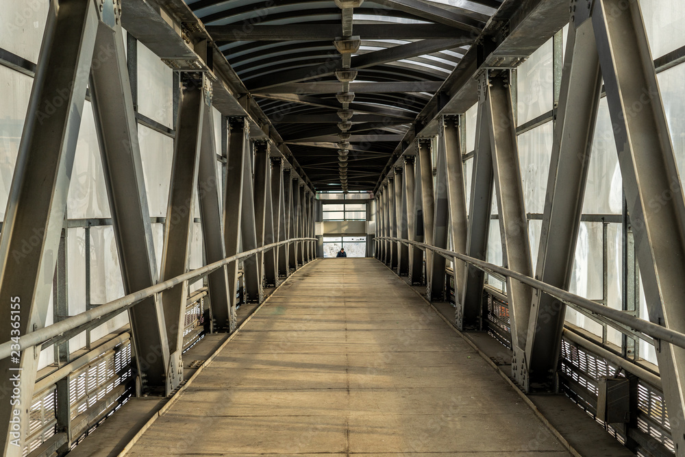 Modern overhead passage from steel and glass, perspective, long tunnel in sunset light