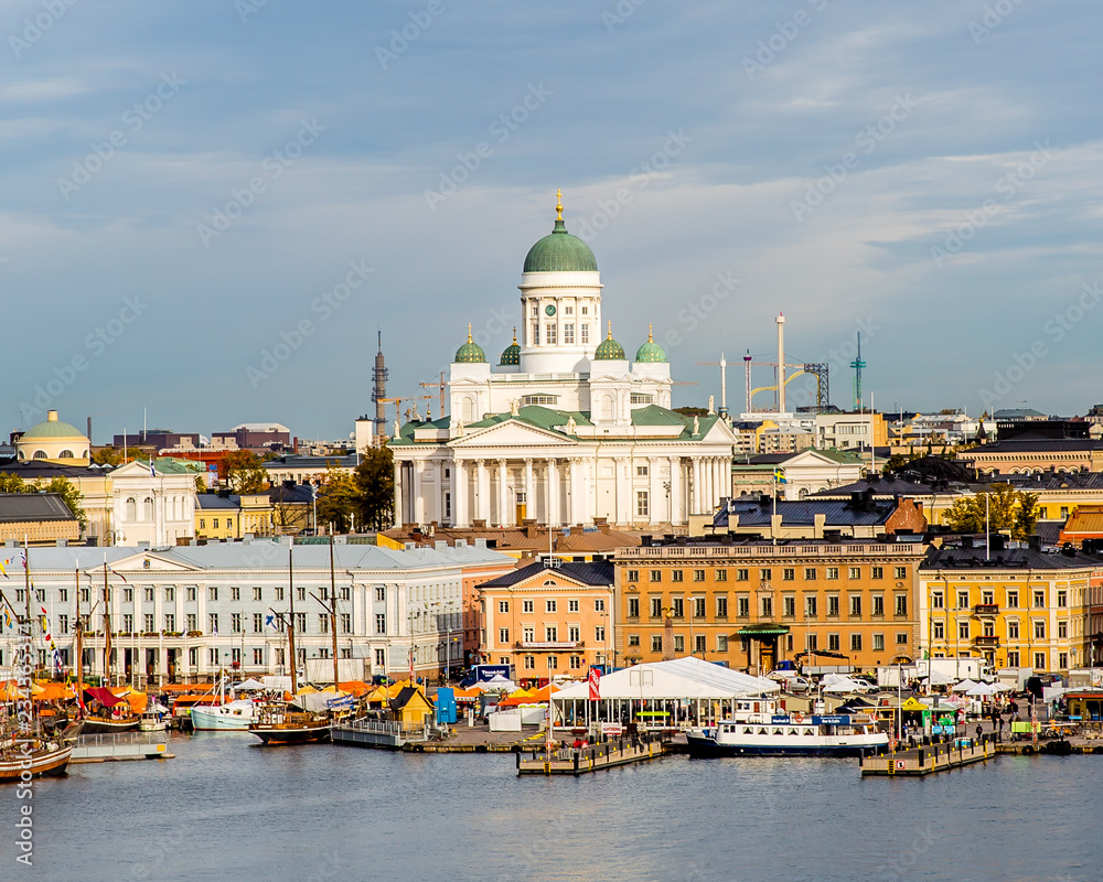 Helsinki, Finland. Scenic cityscape with Helsinki Cathedral, South Harbor, Market Square (Kauppatori) and beautiful cirrus clouds over them in the sunny spring day.