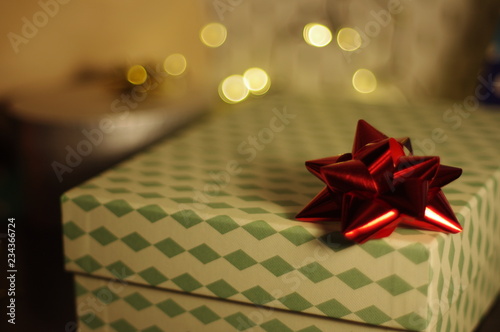 Ornamental gift box with red ribbon on top