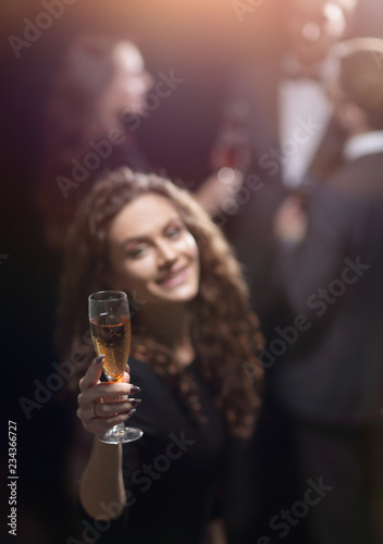 happy young woman raising a glass of champagne