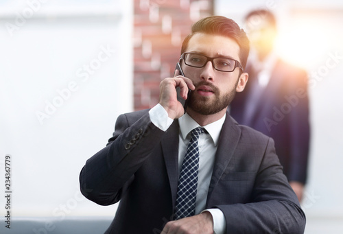 View of a Young attractive business man using smartphone